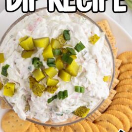 close up overhead shot of a bowl of Dill Pickle Dip topped with slices of pickles and green onions served with crackers