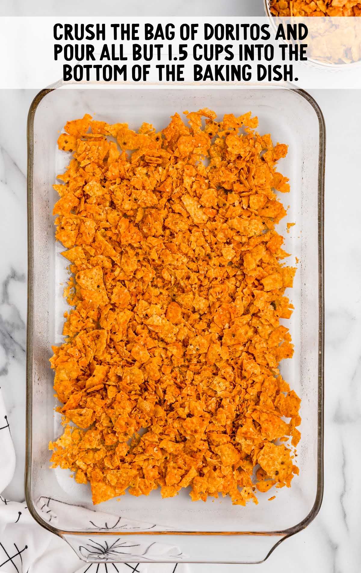 Doritos Cheesy Chicken Casserole process shot of crushed Doritos poured into the bottom of the baking dish