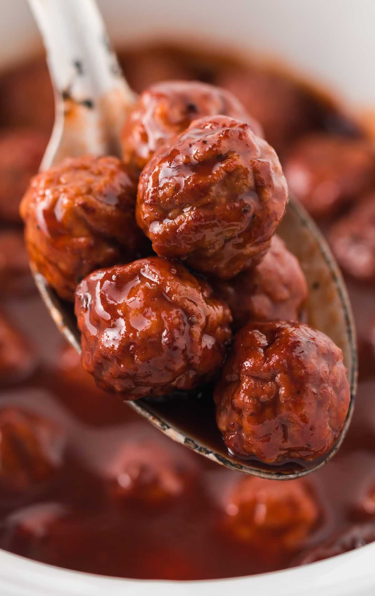 close up shot of a spoonful of Grape Jelly Meatballs