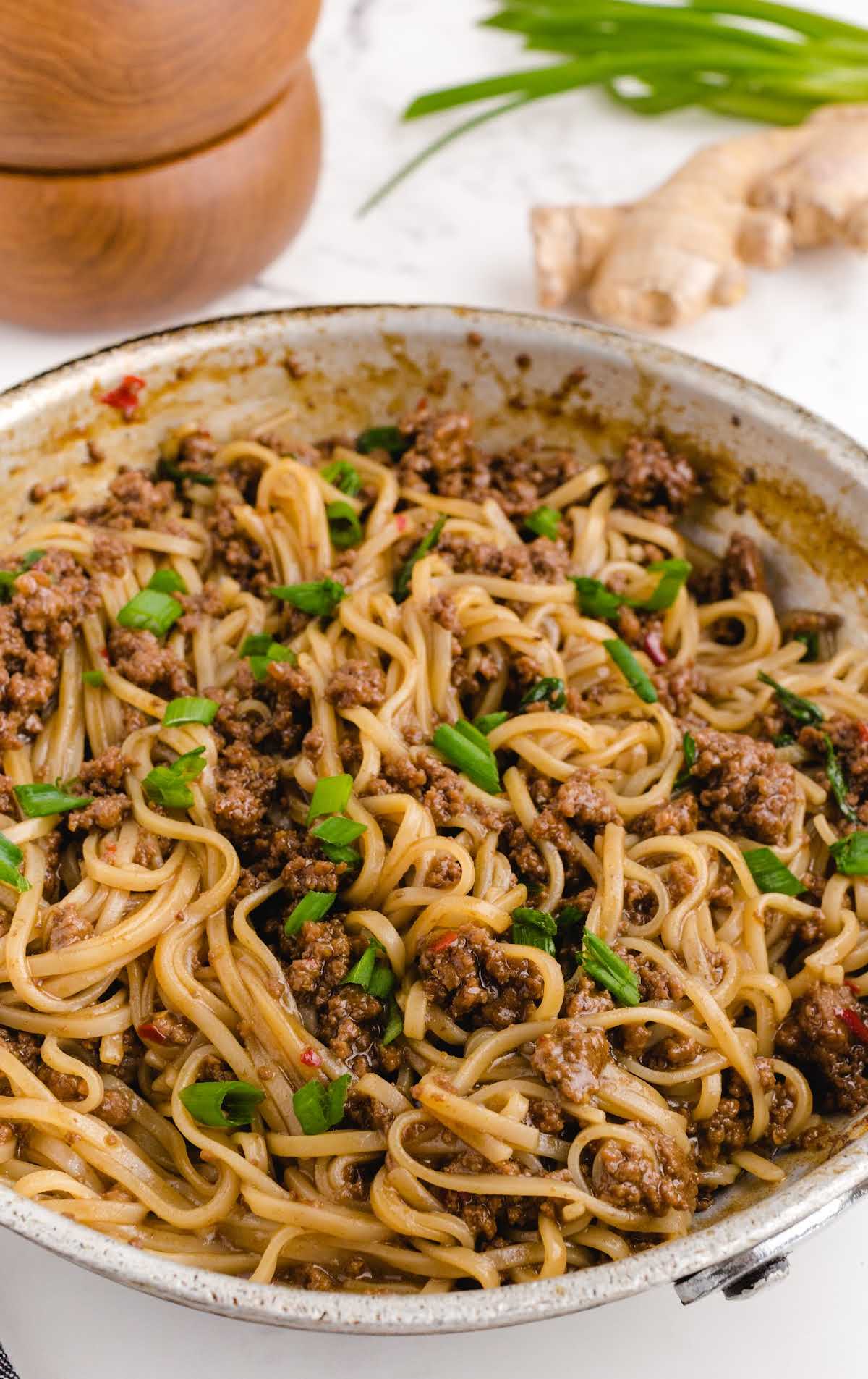 close up shot of a skillet of Mongolian Beef and Noodle Recipe garnished with green onions