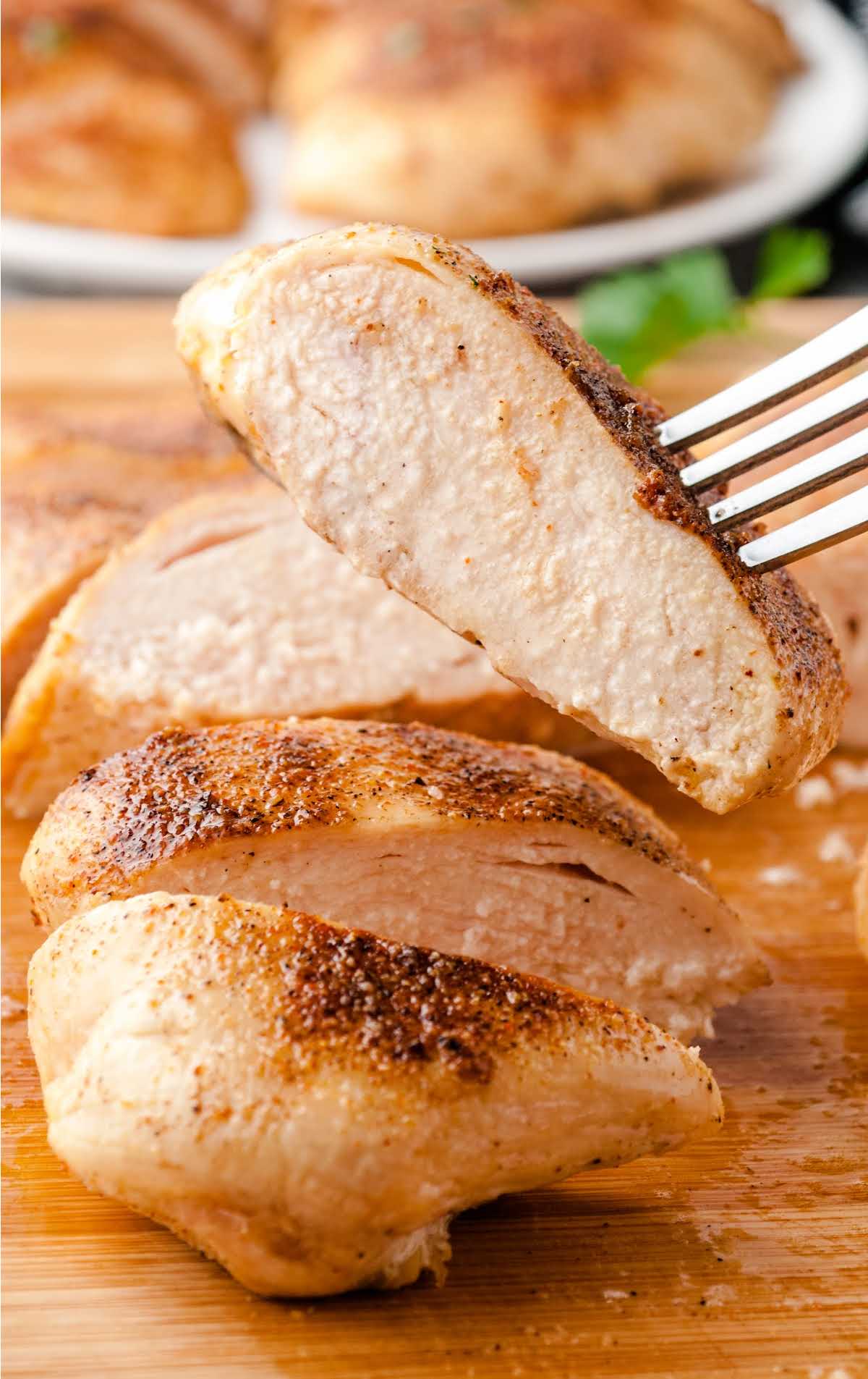 close up shot of a Oven Baked Chicken sliced on a wooden board