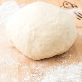 close up shot of a ball of Pizza Dough Recipe on a floured wooden board