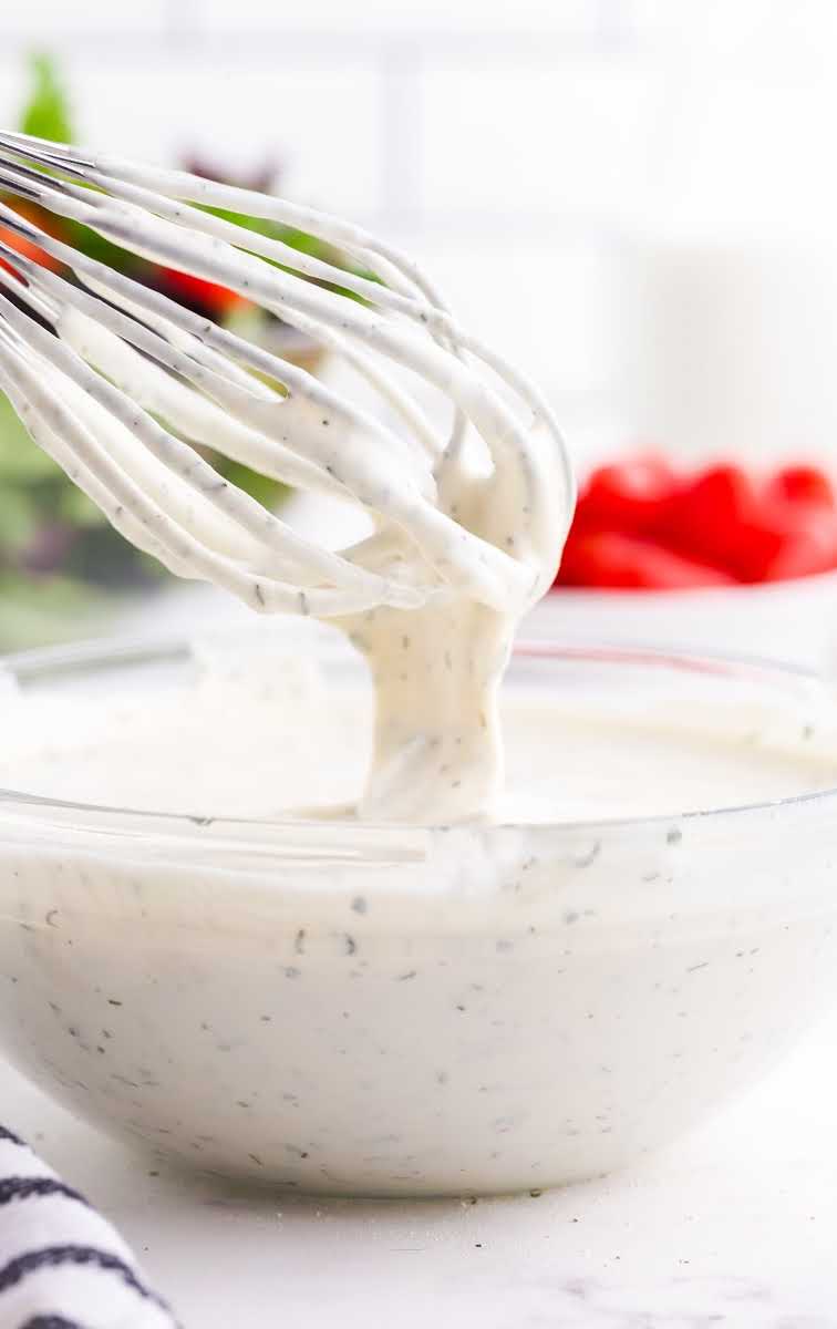close up shot of a bowl of Ranch Dressing with a whisk