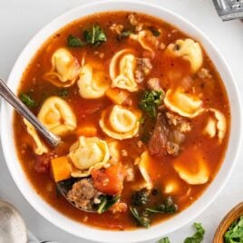 close up overhead shot of a bowl of Tortellini Soup with a spoon