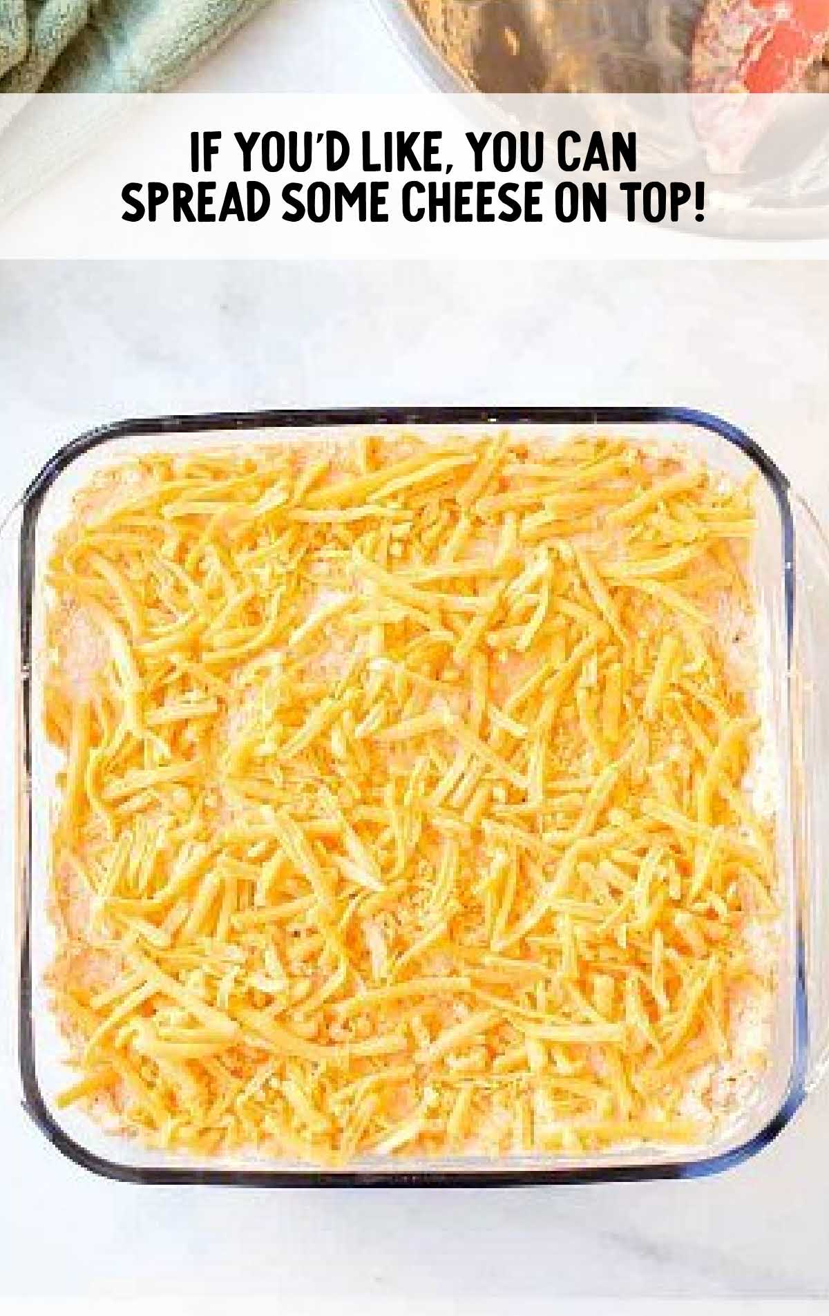 buffalo chicken dip process shot of shredded cheese placed on top of dip