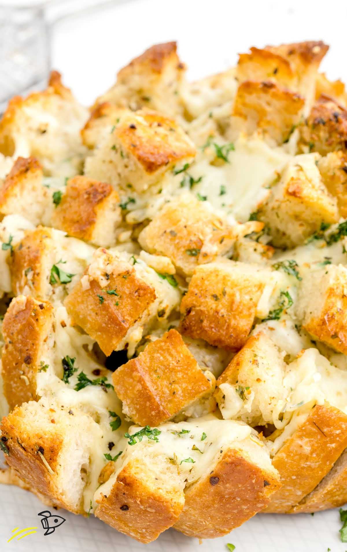 close up shot of cheesy pull-apart bread garnished with parsley