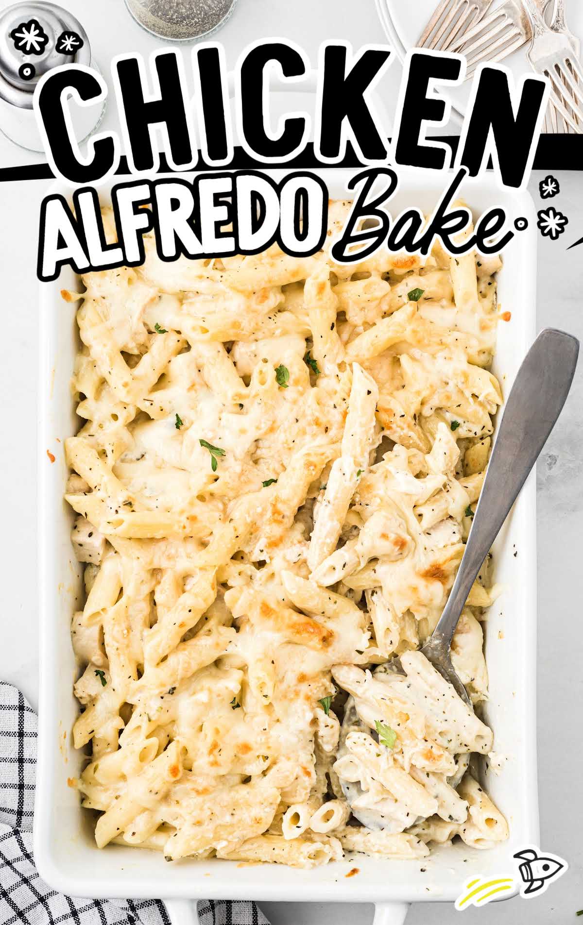 close up overhead shot of a baking dish full of chicken alfredo bake with a spoon