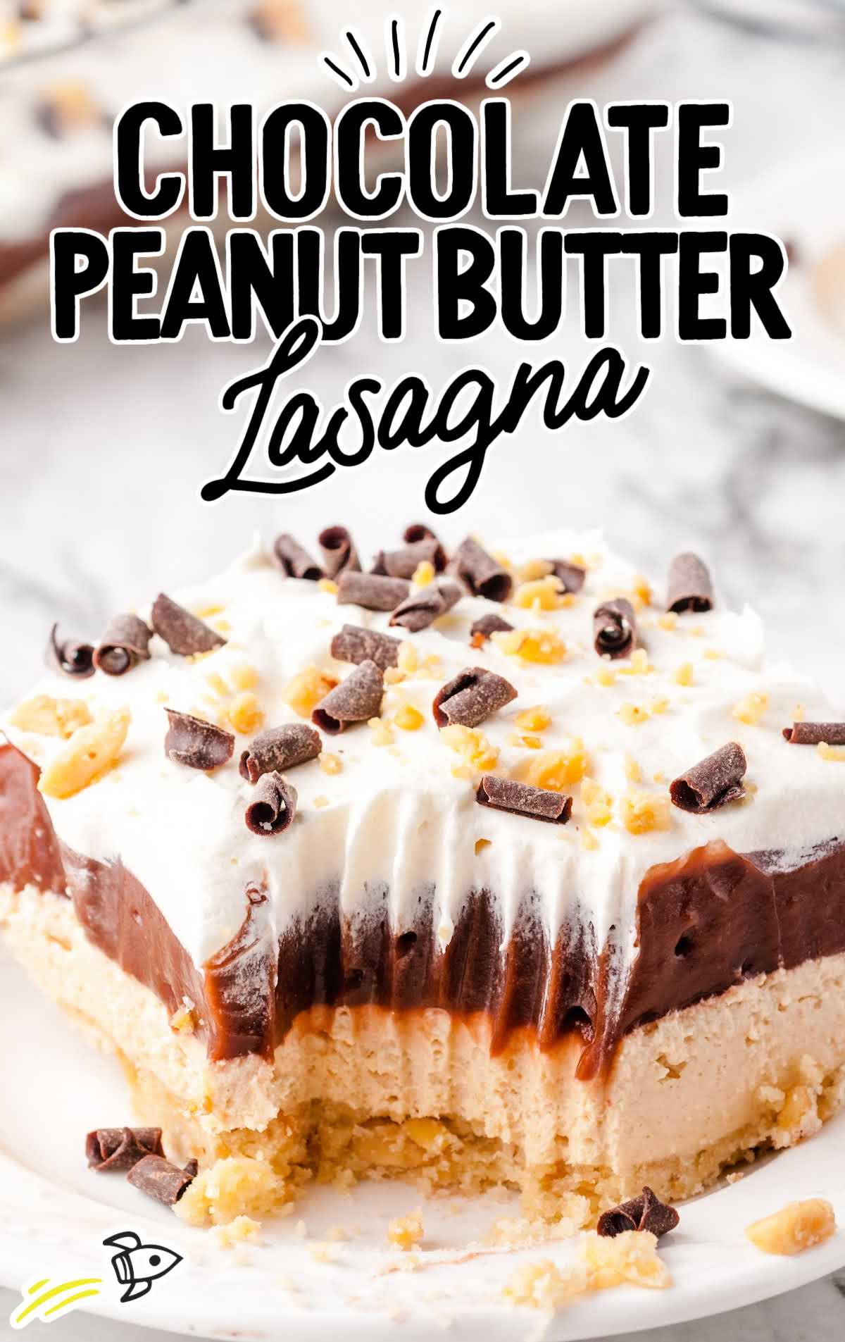 close up shot of a slice of chocolate peanut butter lasagna garnished with peanuts and chocolate shavings on a plate