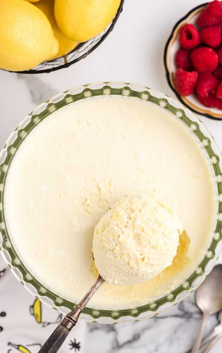 overhead shot of a bowl of lemon fluff with a scoop of lemon fluff on a spoon