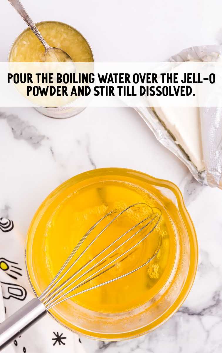 boiling water and jello powder whisked together in a bowl