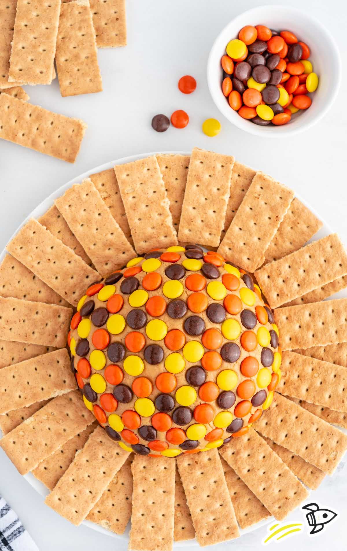 overhead shot of a serving plate of peanut butter ball surrounded by graham crackers