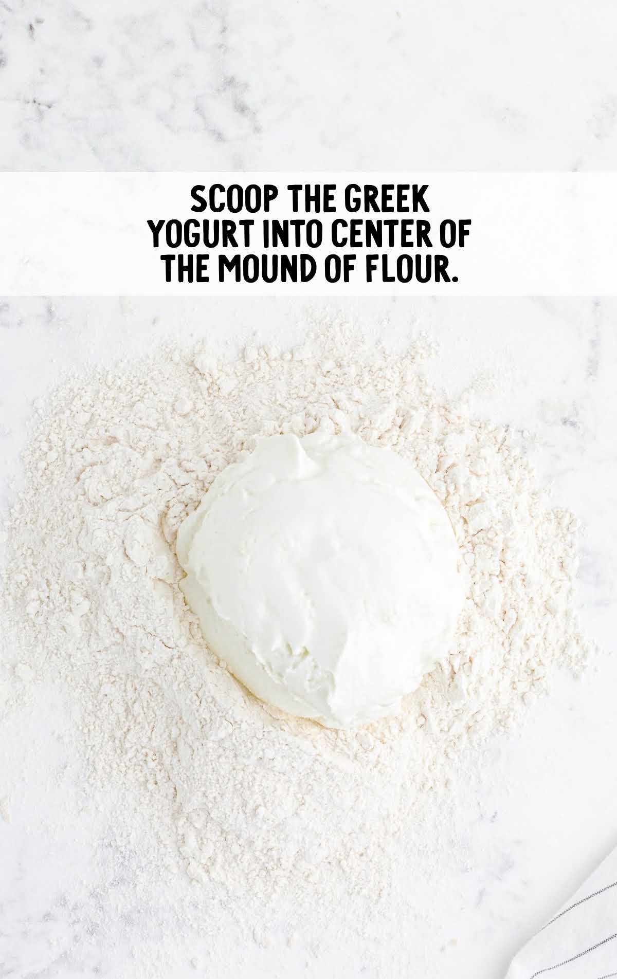 greek yogurt placed into the center of the mound of flour