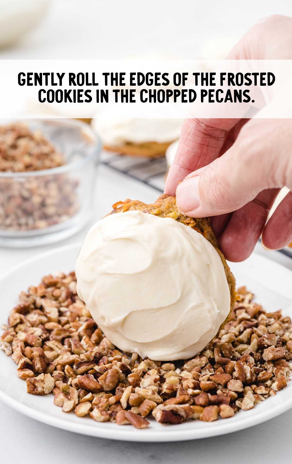cookies with cream cheese frosting being dipped into chopped pecans