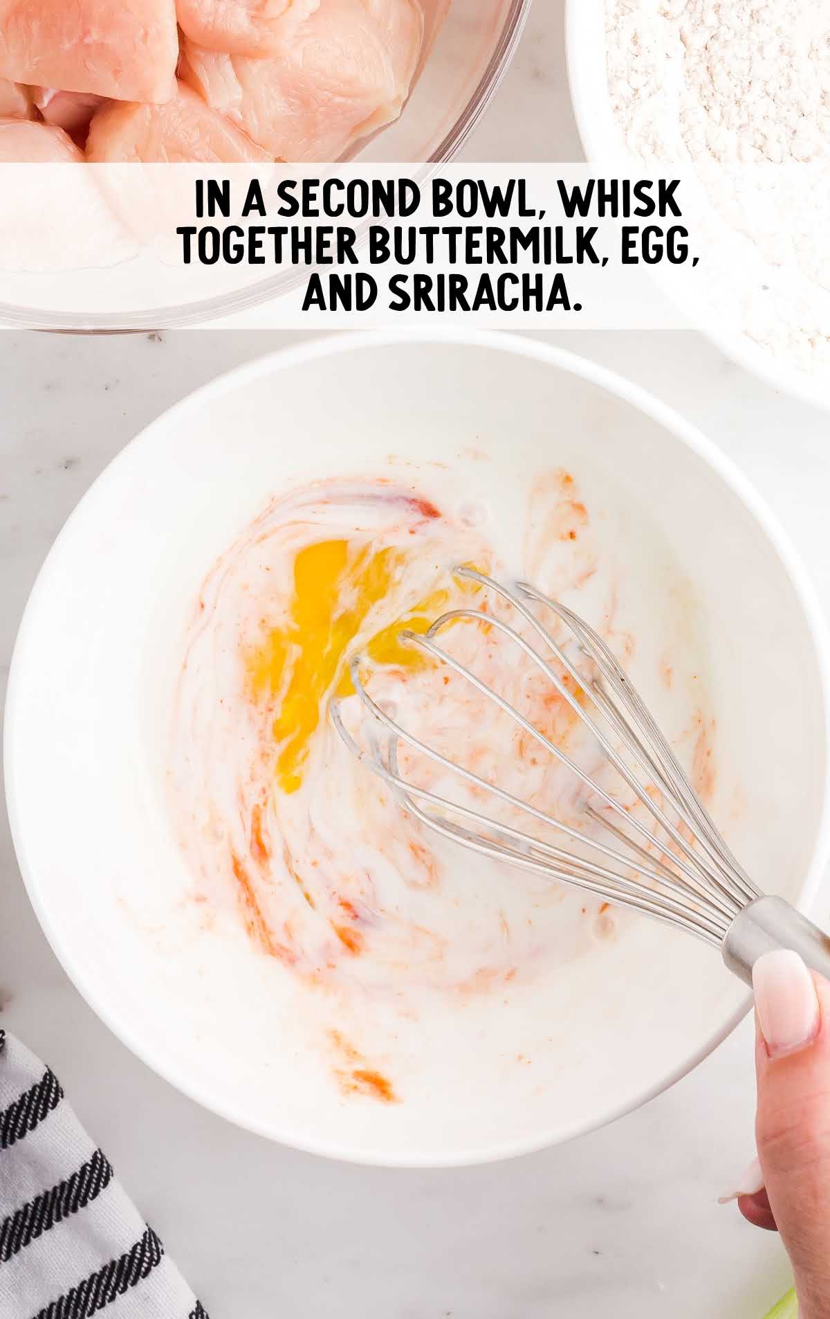 buttermilk, egg, and sriracha whisked together in a bowl