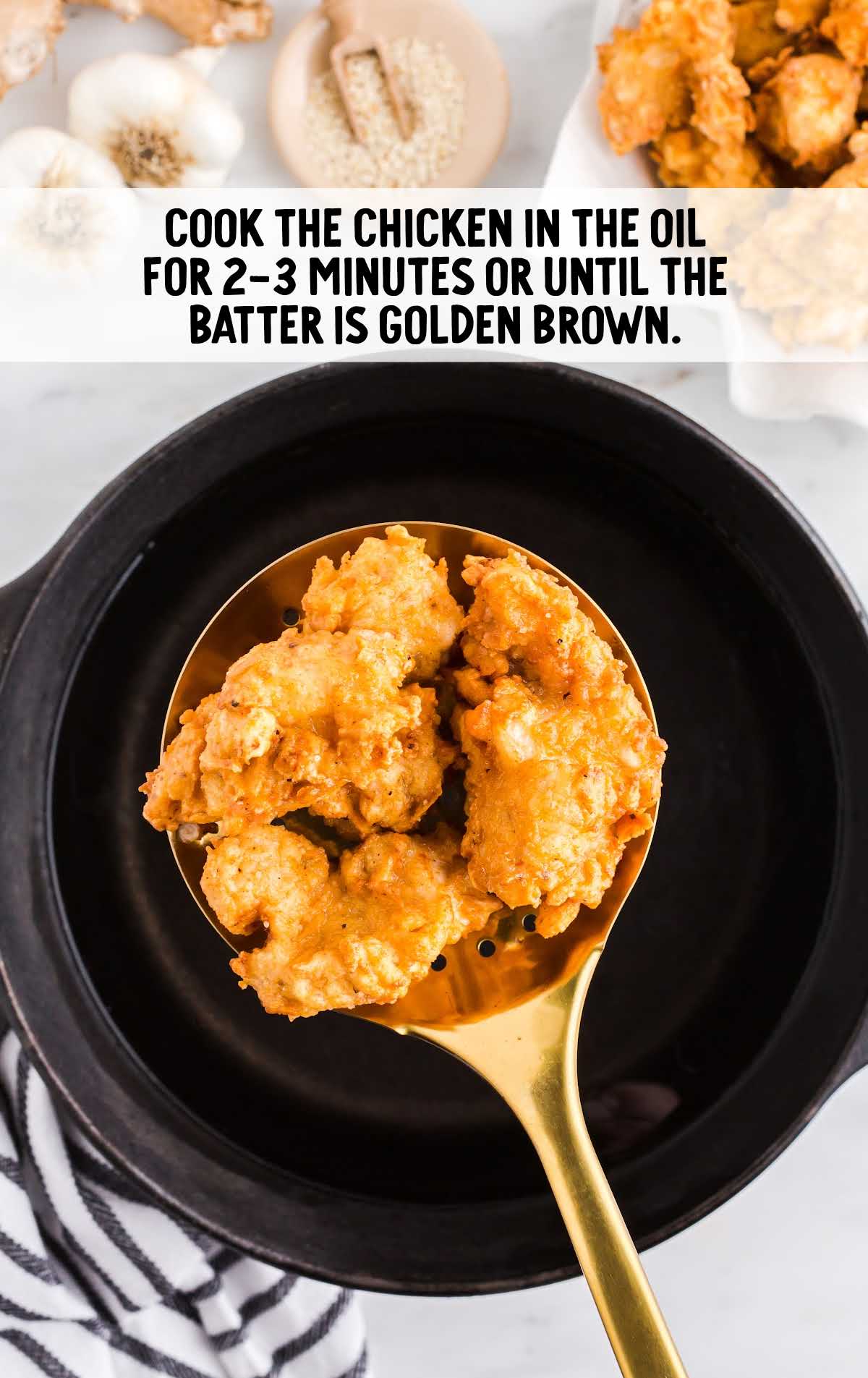pieces of chicken fried into a pot of hot oil