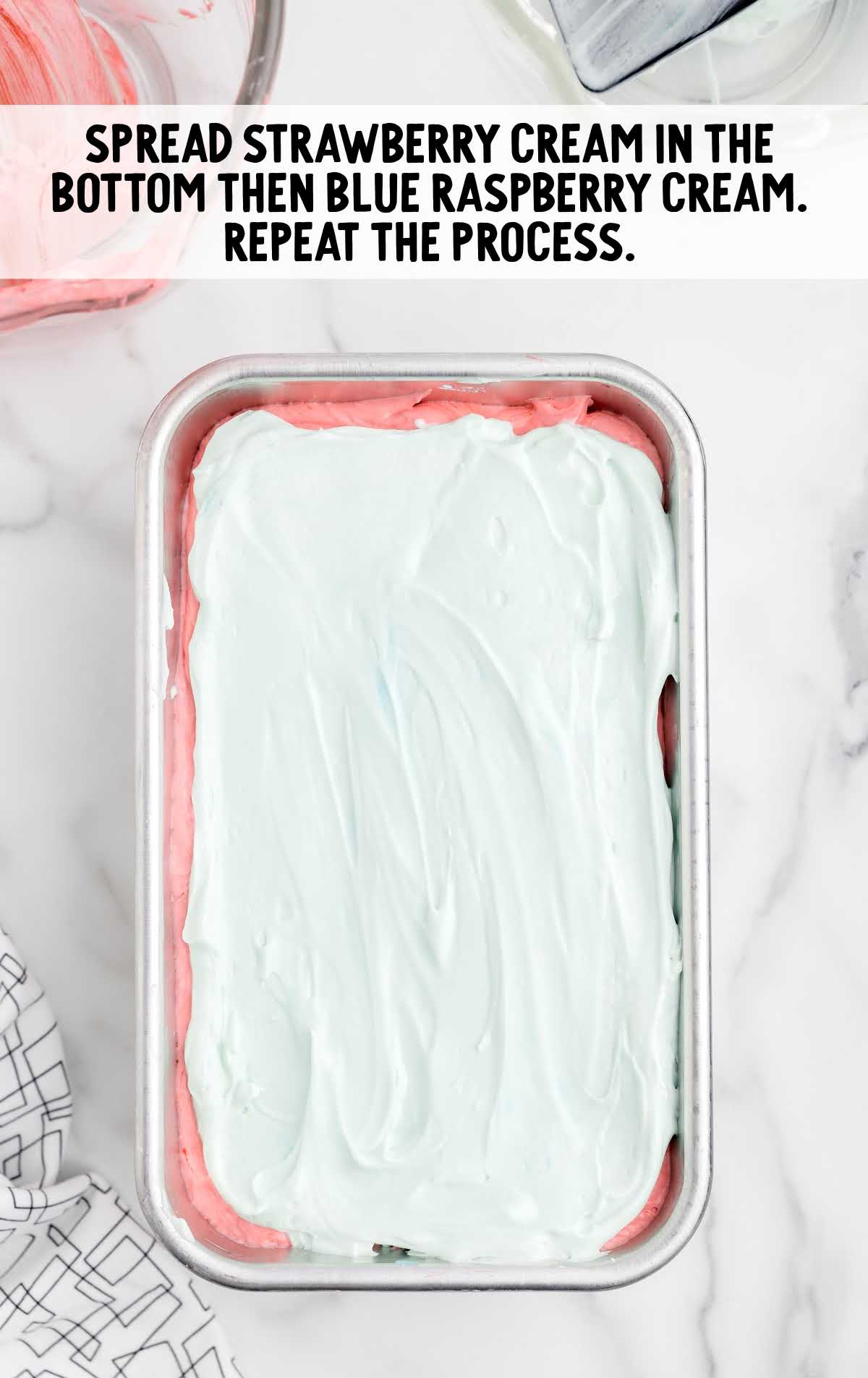 strawberry cream spread on the bottom on a baking dish and the blue raspberry cream spread on top