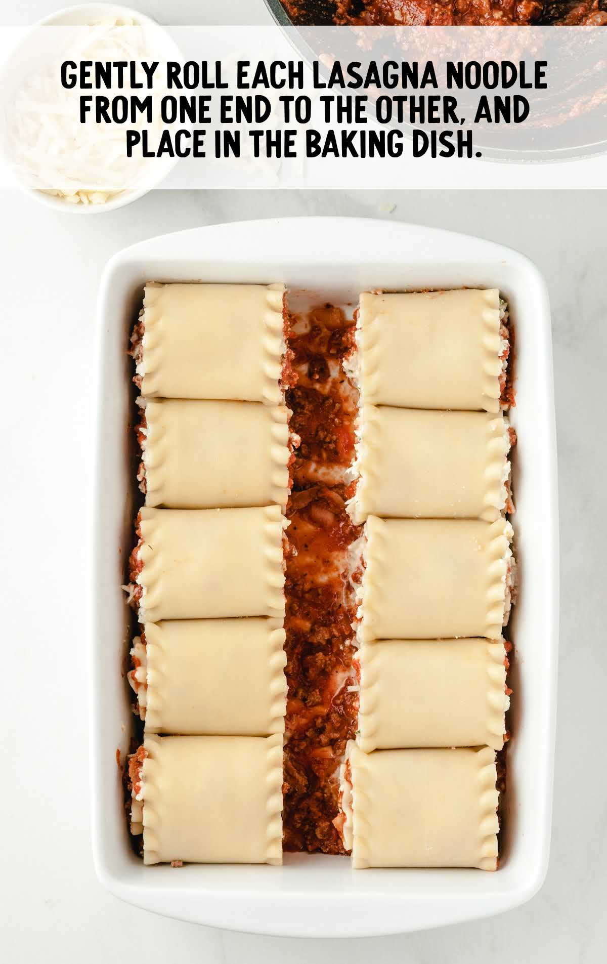 lasagna noodles rolled and placed in a baking dish