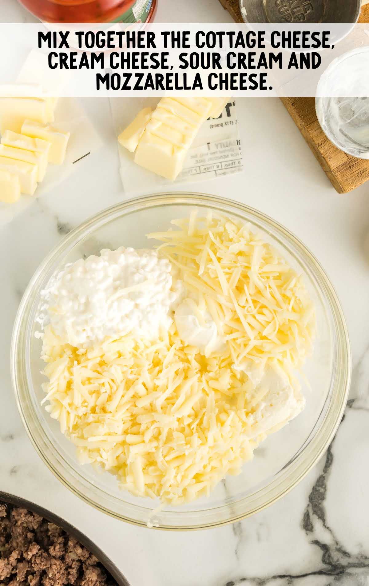 cheeses, cream cheese, and sour cream combined in a bowl