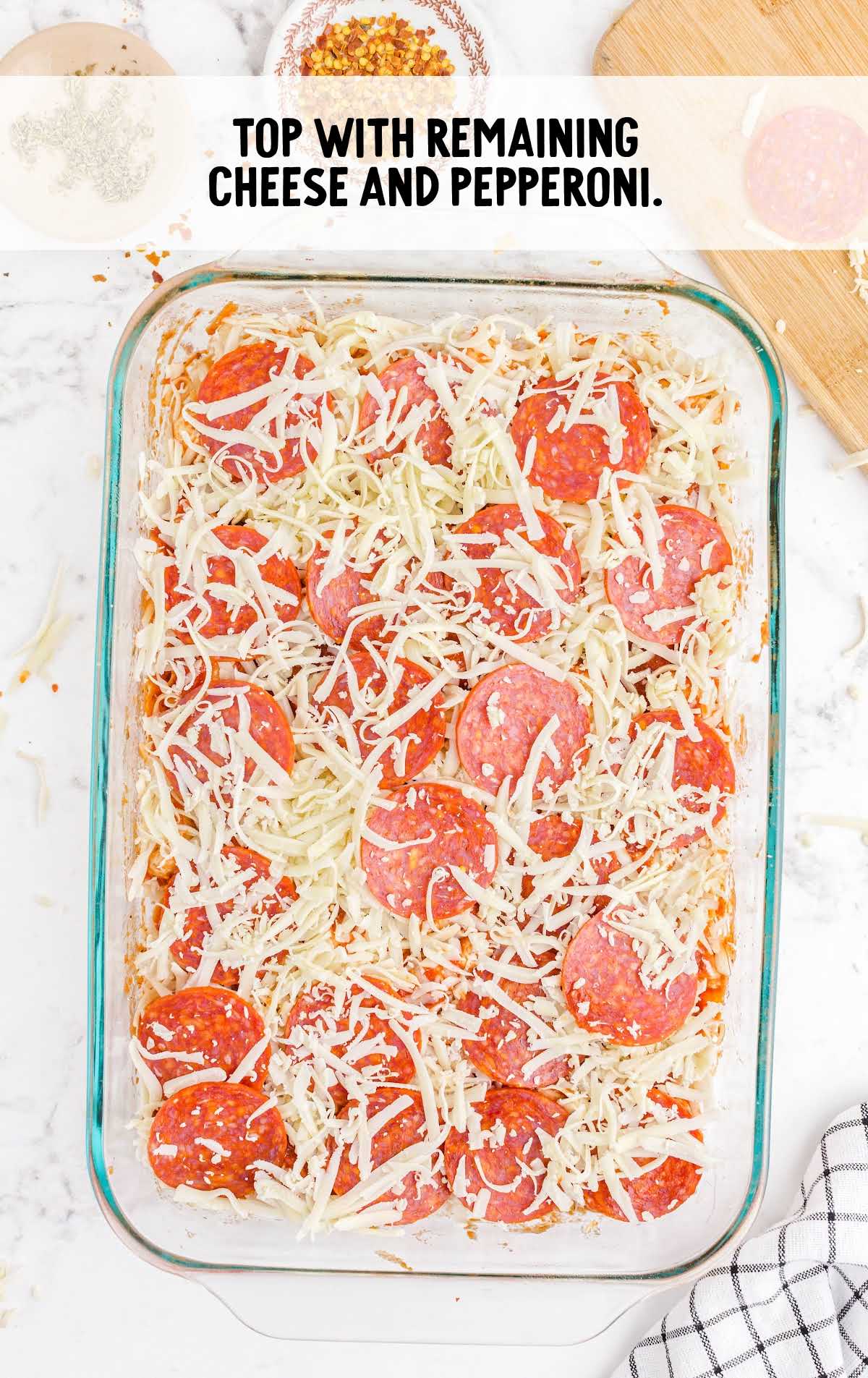 pizza topped with shredded cheese and pepperoni slices in a baking dish