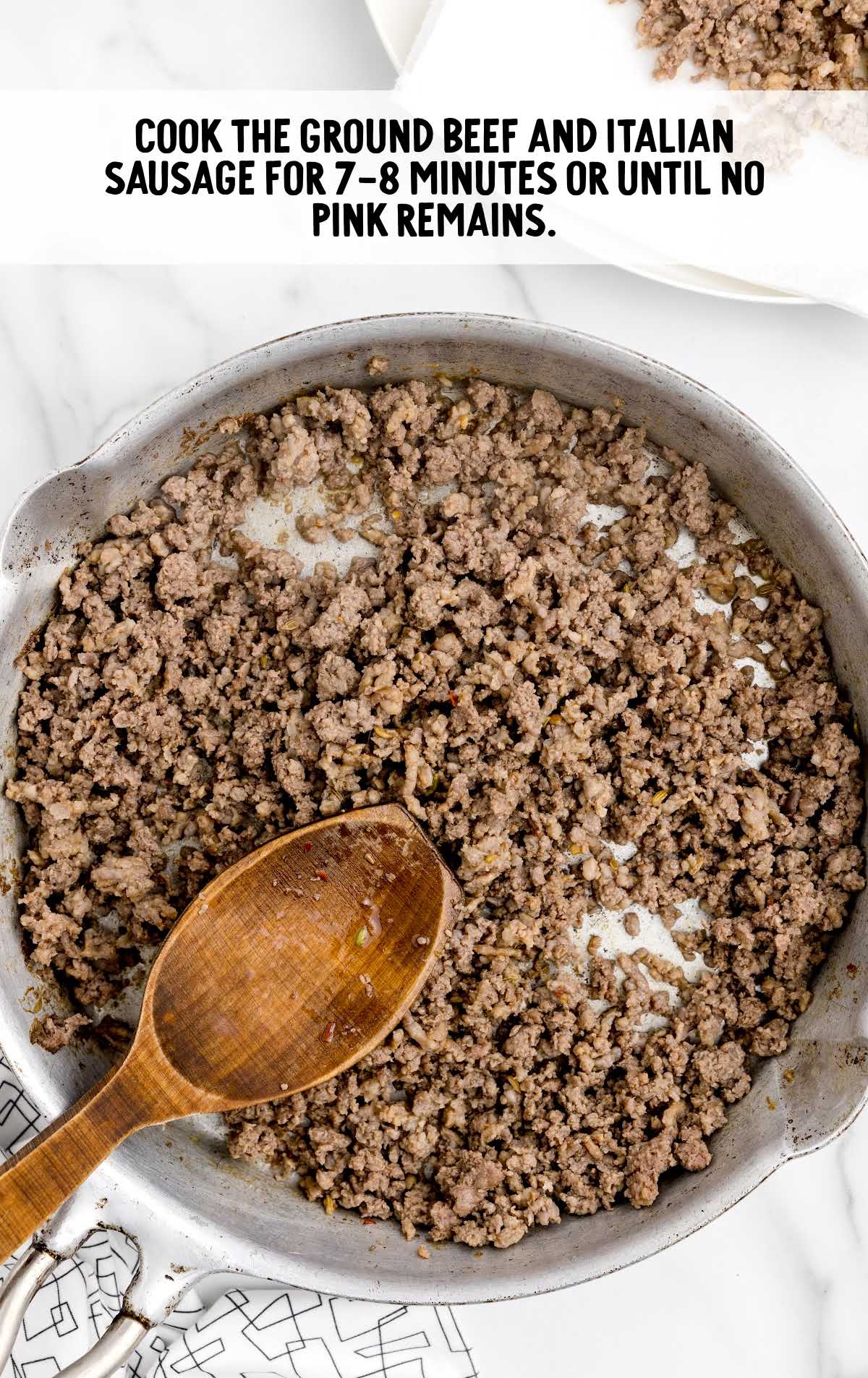 ground beef and Italian sausage being cooked and browned in a skillet