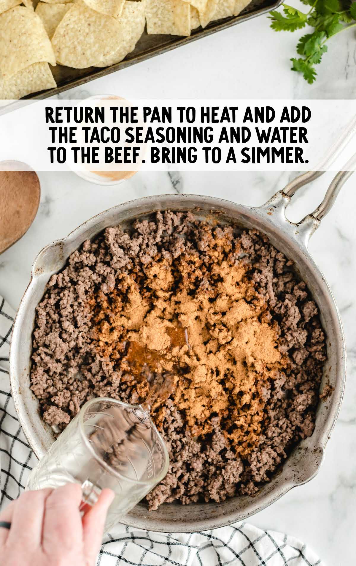 Sheet Pan Nachos process shot of ground beef being cooked in a pot with taco seasoning and water