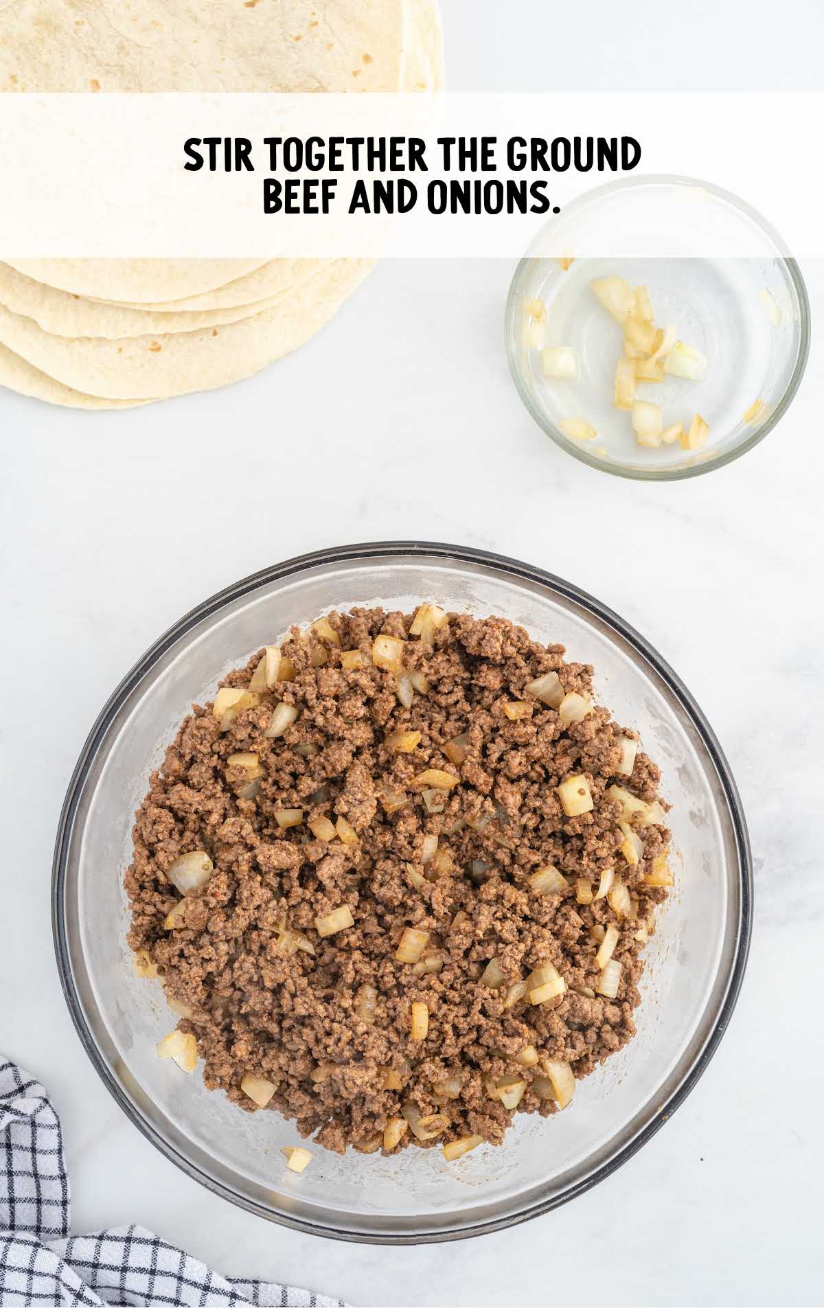 ground beef and onions stirred together in a bowl