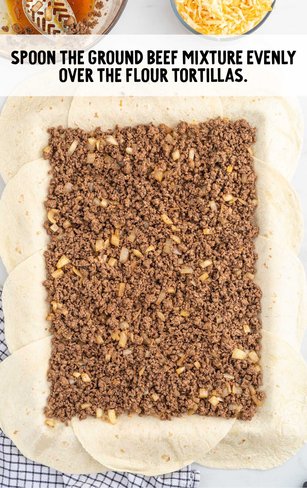 ground beef mixture spread over the flour tortillas on a sheet pan