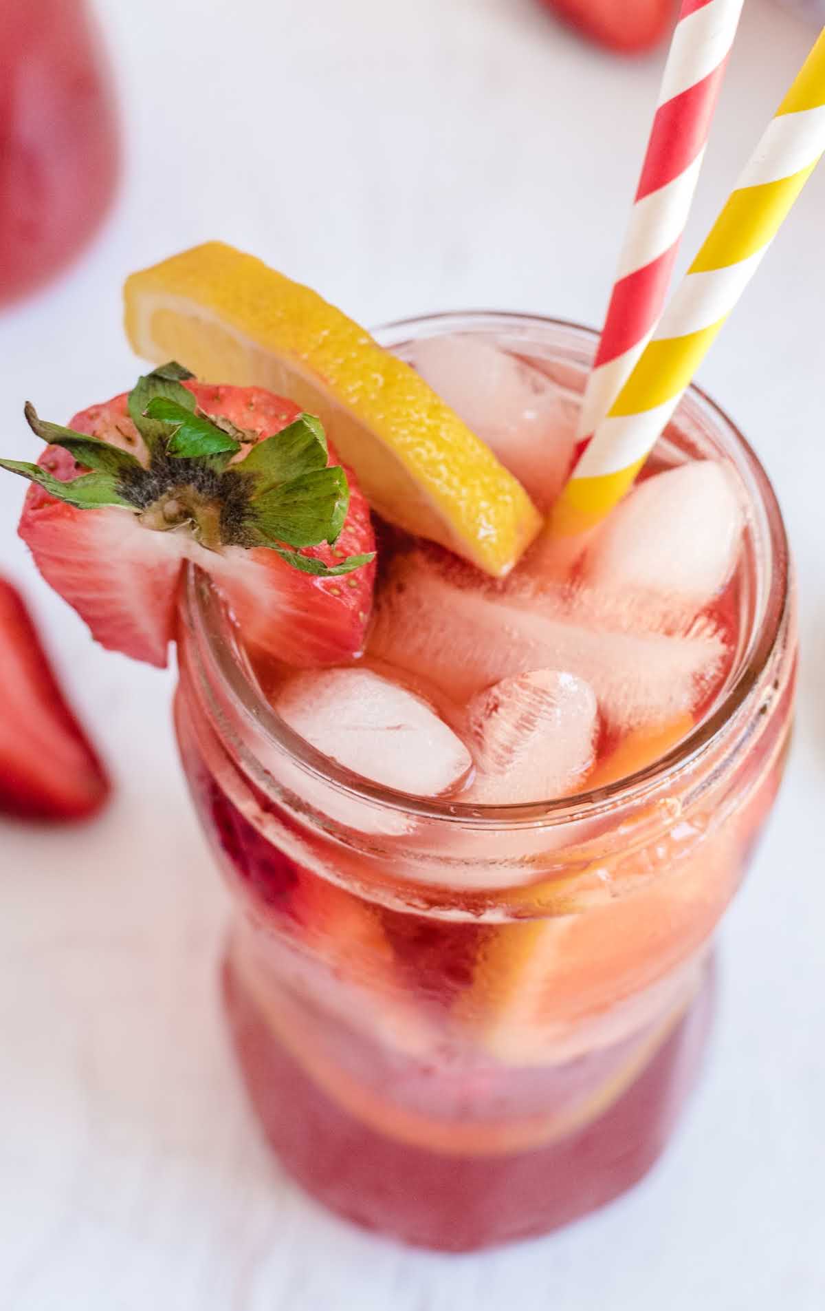 close up shot of a glass of Southern Strawberry Sweet Tea garnished with strawberry an lemon slices