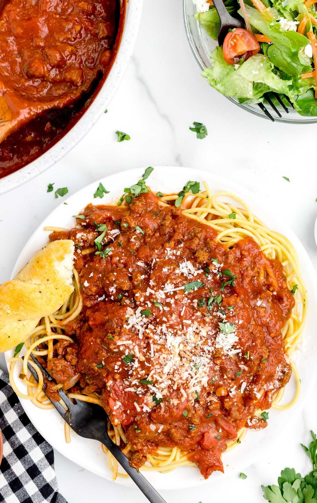 overhead shot of a plate of Spaghetti noodles topped with Meat Sauce and garnished with parsley