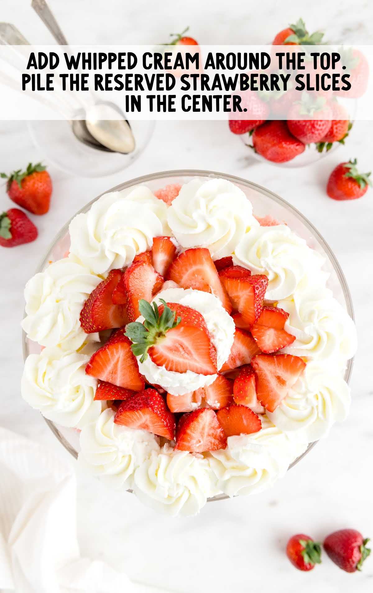 trifle topped with whipped cream and chopped strawberries
