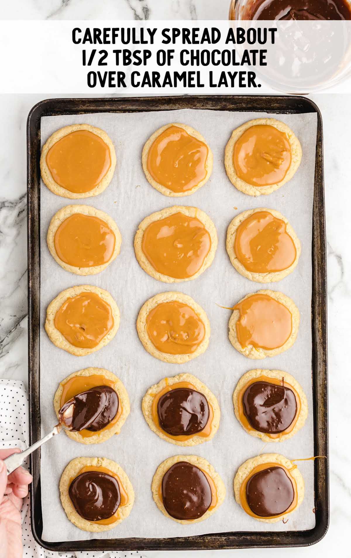 chocolate spread over the caramel layer on the cookies