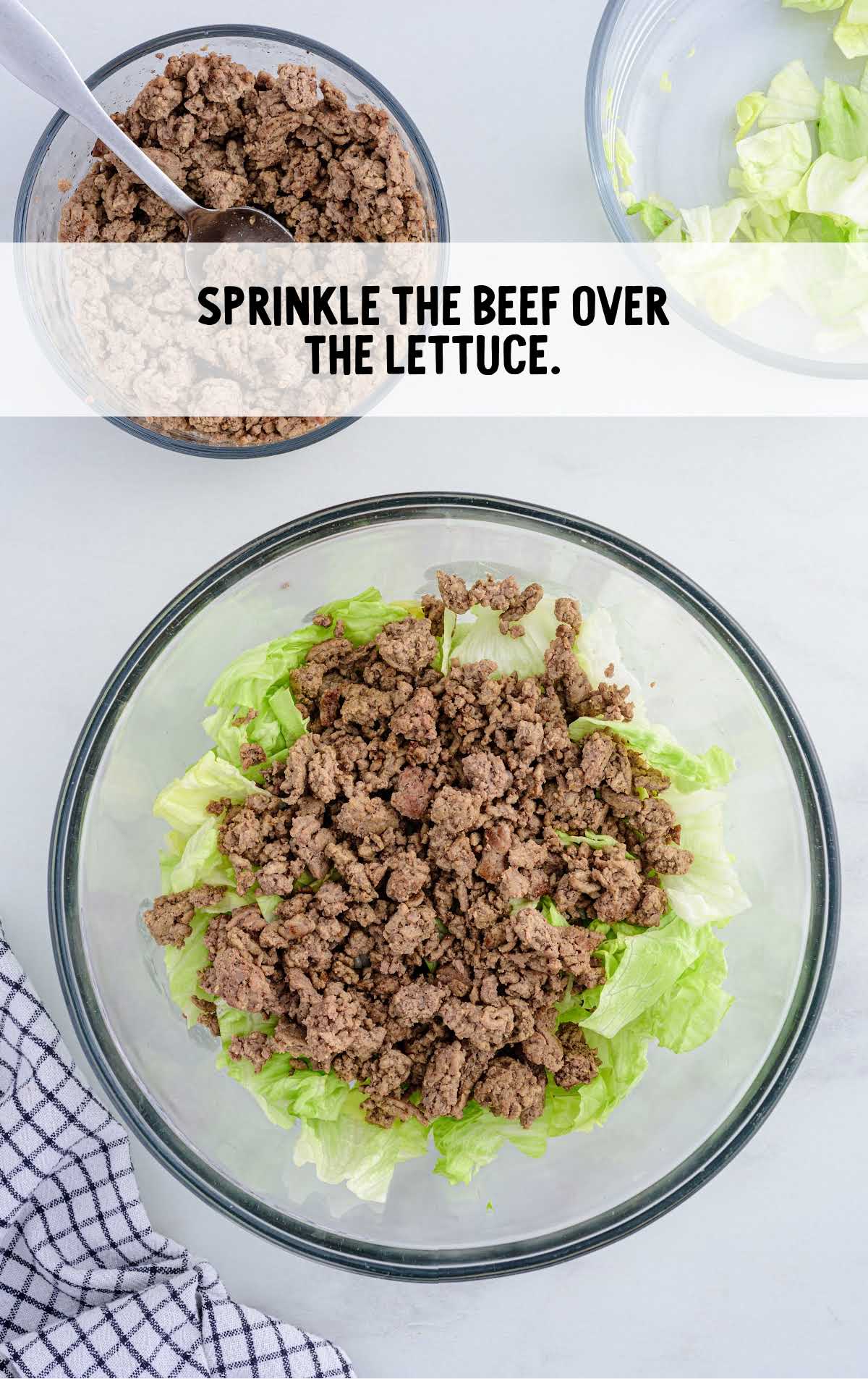 cooked ground beef added to the bowl of lettuce