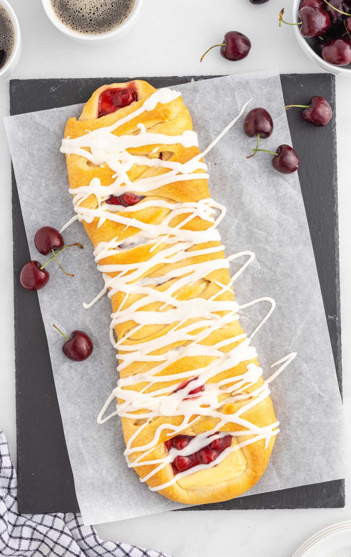 close up overhead shot of cherry breakfast braid surrounded by cherries