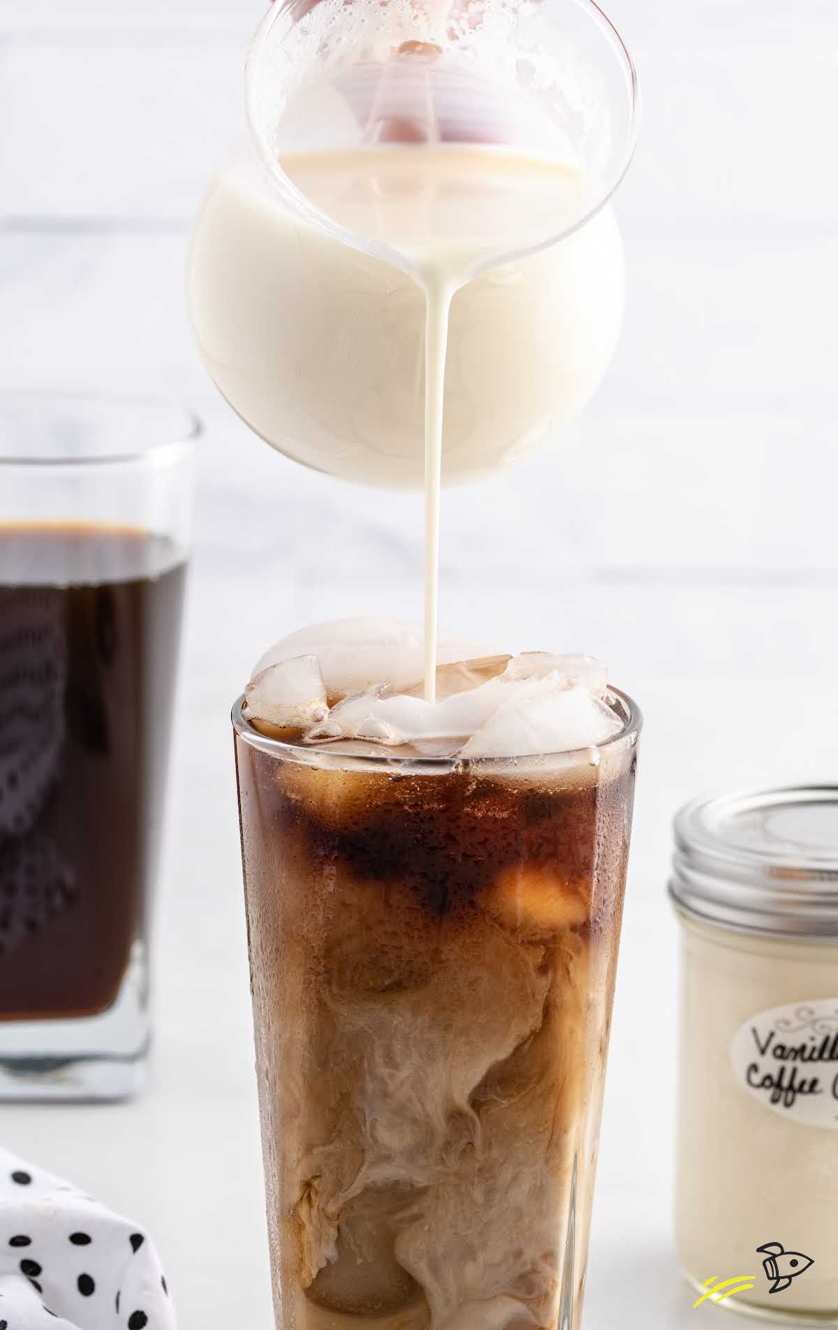 close up shot of homemade coffee creamer being poured into a cup of coffee