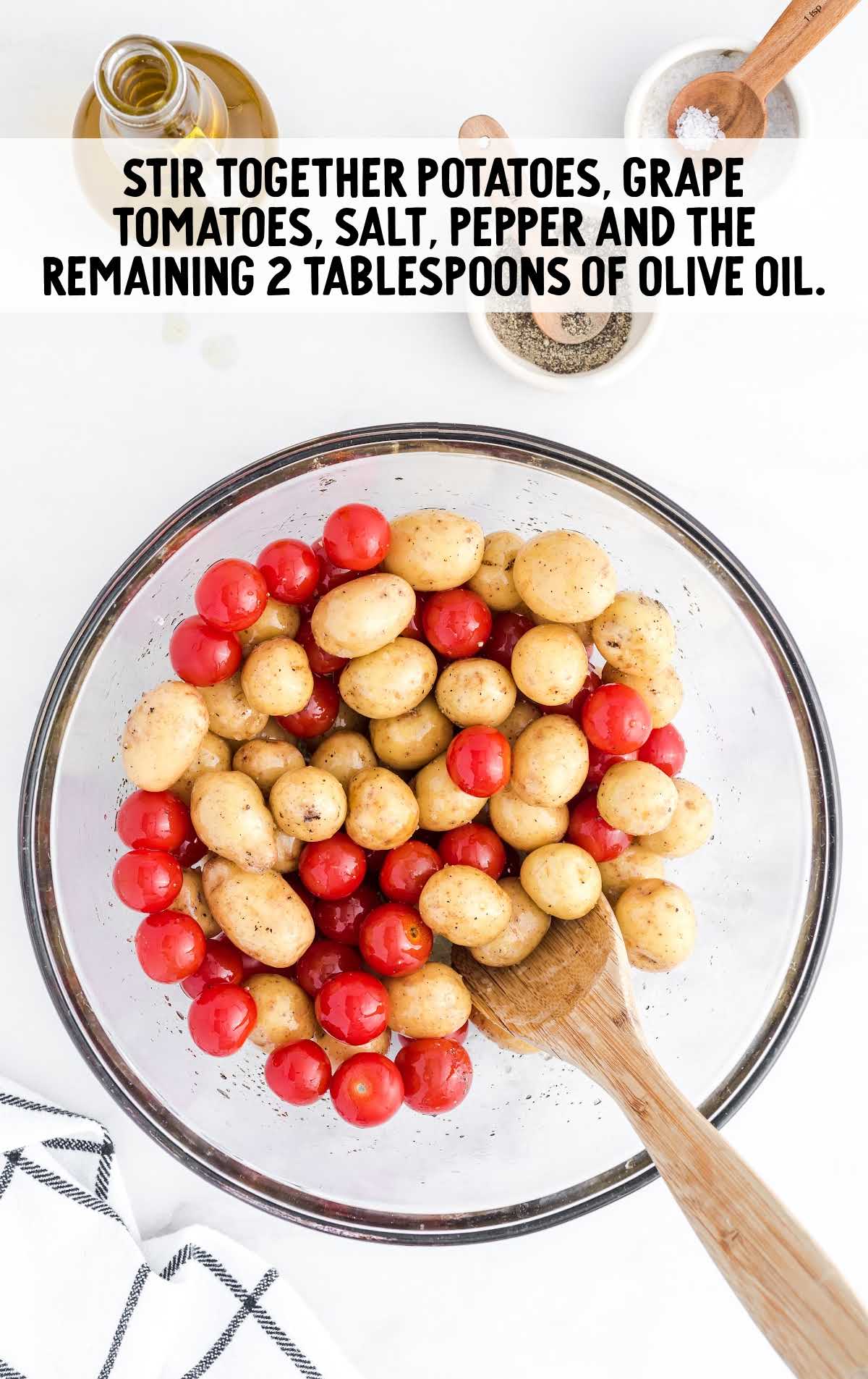 tomatoes and potatoes being combined in a bowl with olive oil