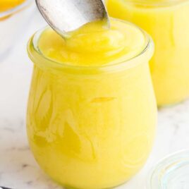 close up shot of a jar of Lemon Curd with a spoon dipped into it