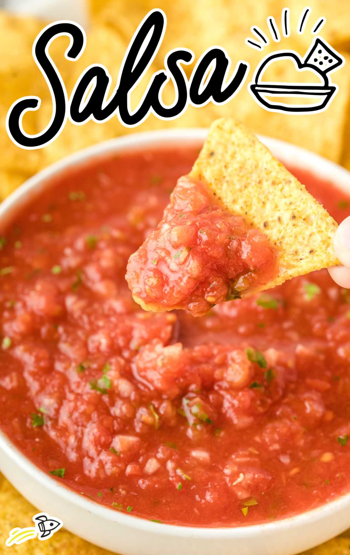 close up shot of a bowl of salsa with a tortilla chip being dipped into it