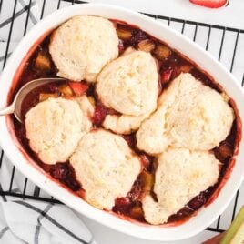 close up overhead shot of a Strawberry Rhubarb Cobbler cobbler in a baking dish placed on a cooling rack