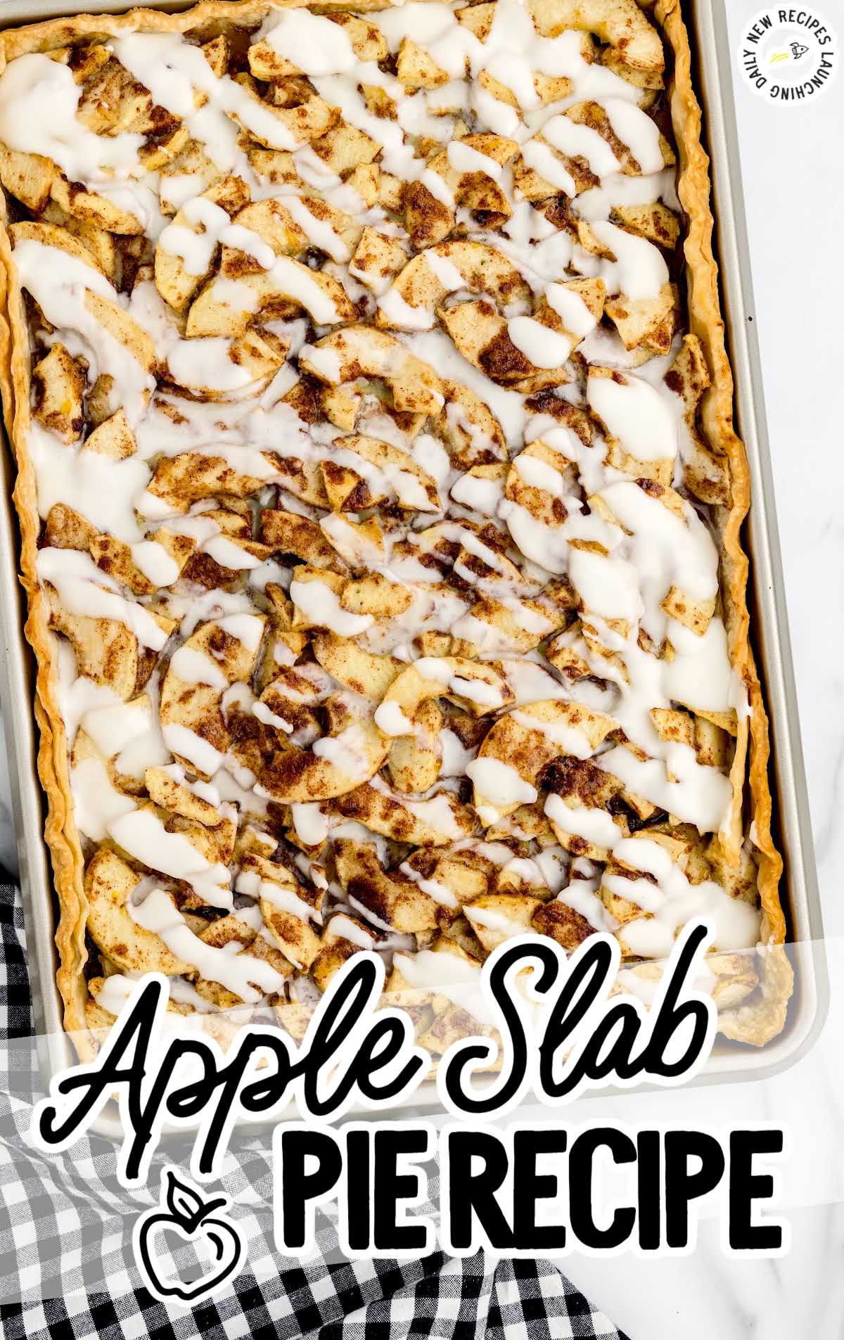 overhead shot of a Apple Slab Pie drizzled with glaze in a baking dish