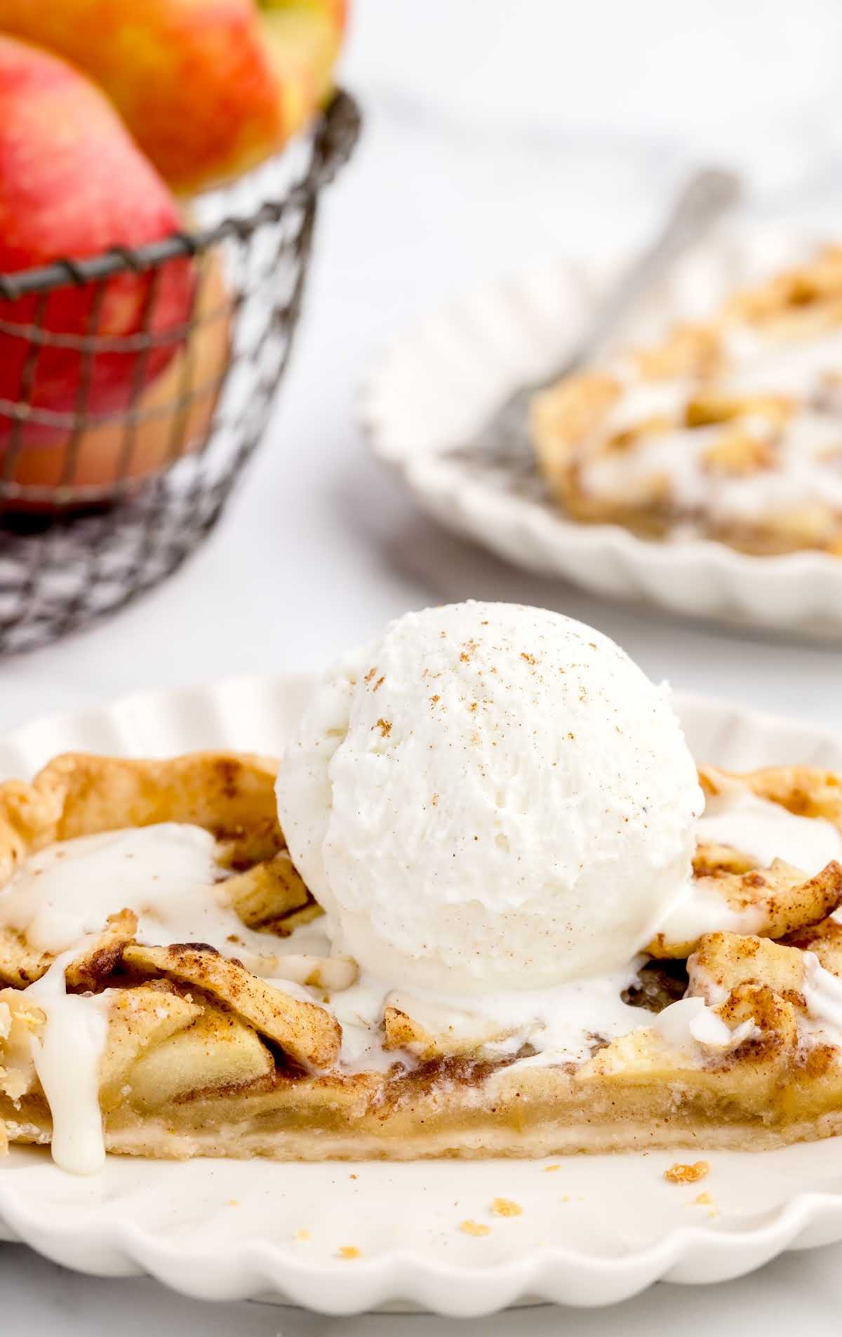close up shot of a slice of Apple Slab Pie topped with a scoop of vanilla ice cream on a plate