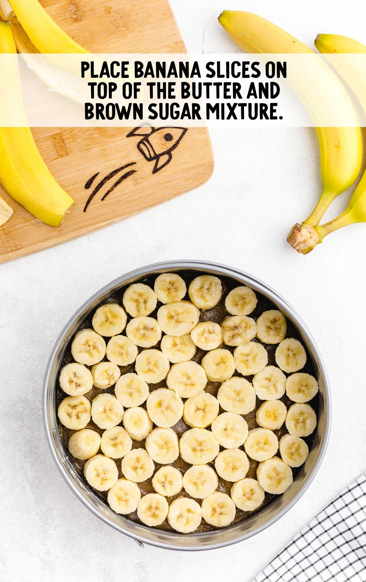 banana slices placed on top of the butter and brown sugar mixture in a cake pan