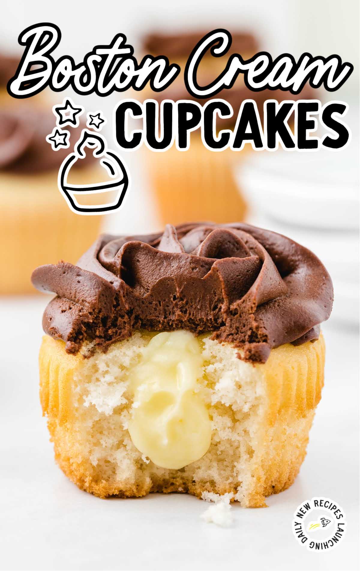 close up shot of a chocolate frosted cupcake showing it's inside Boston Cream filling