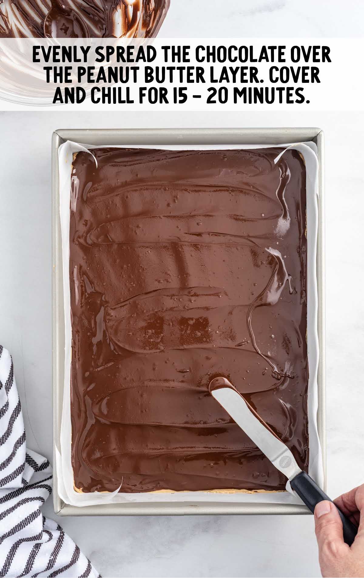 chocolate spread over the peanut butter layer in a baking dish