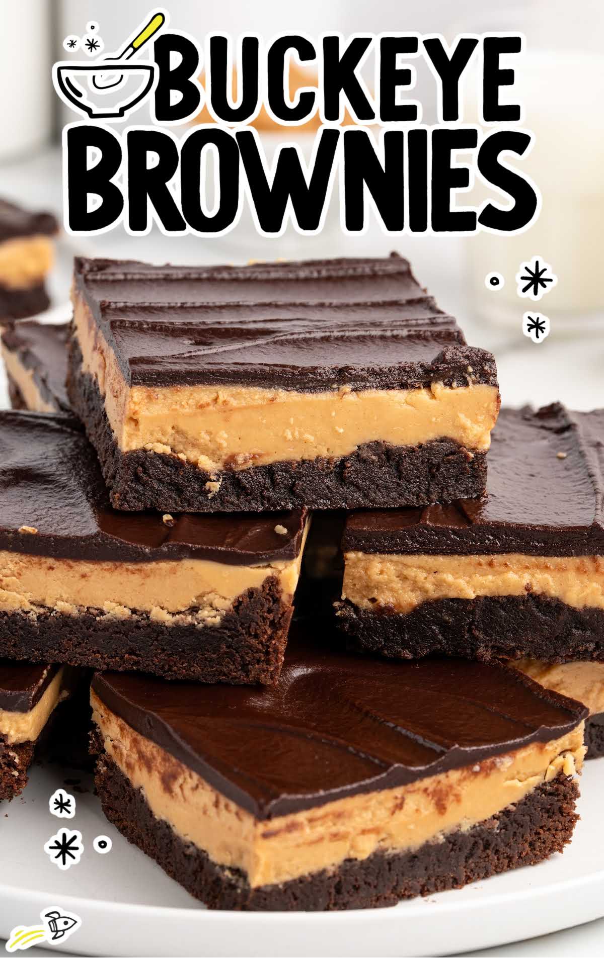 Buckeye brownies stacked on a plate with text overlay reading “Buckeye Brownies,” highlighting the chocolate and peanut butter layers.