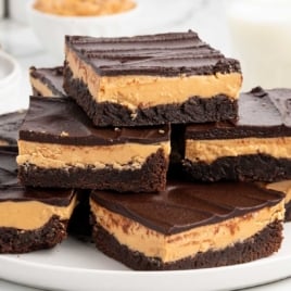 Plate of buckeye brownies showing layers of brownie base, thick peanut butter center, and glossy chocolate ganache.