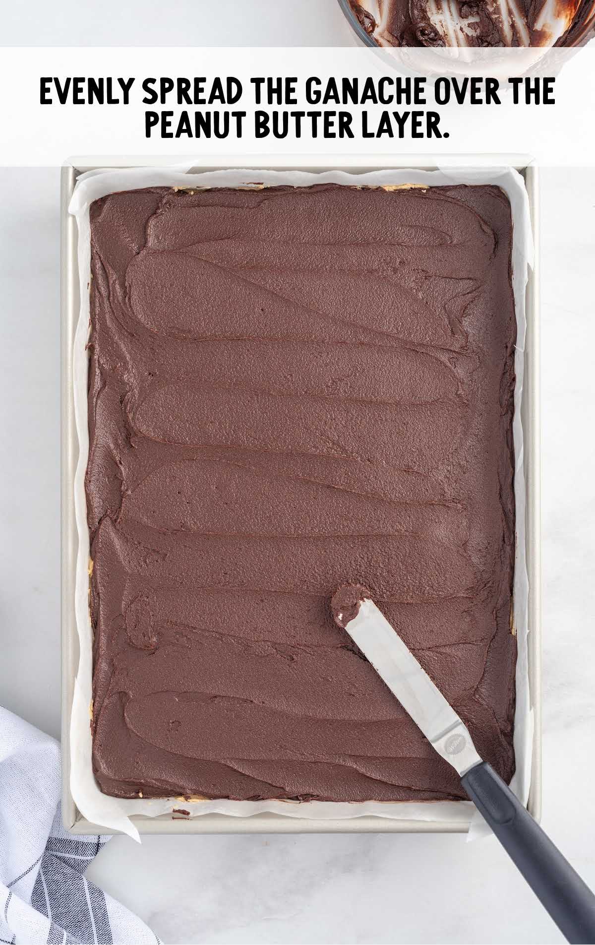 chocolate ganache spread over the peanut butter layer in a baking dish