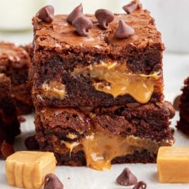 close up shot of Caramel Brownies topped with chocolate chips and piled on top of each other