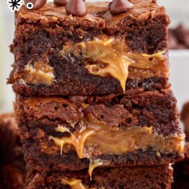 close up shot of Caramel Brownies topped with chocolate chips and piled on top of each other