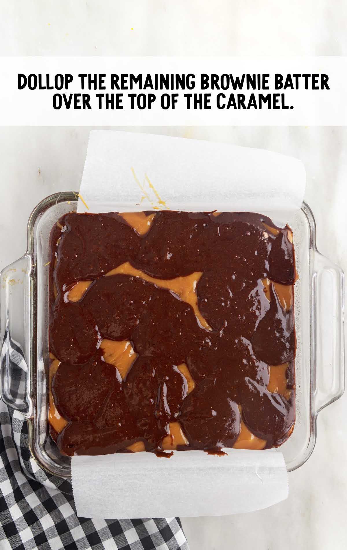 brownie batter spread over top of the caramel in the baking dish