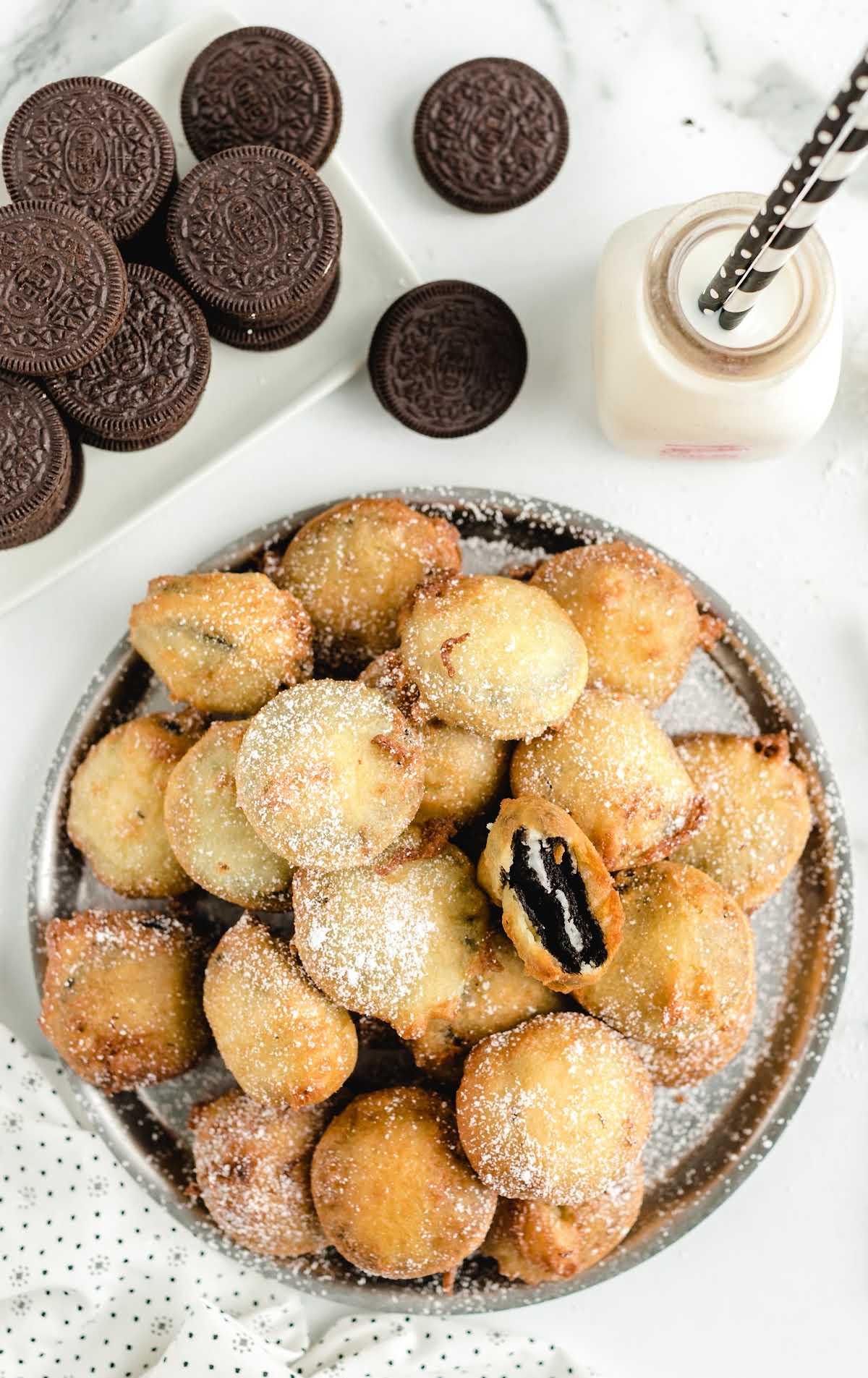 close up overhead shot of deep fried oreos sprinkled with powdered sugar on a plate